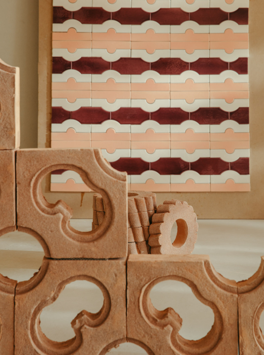 Una scena con diverse piastrelle di terracotta con motivi geometrici, su uno sfondo di carta