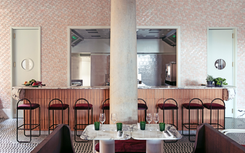 Interno di un ristorante moderno con bancone in legno e marmo.